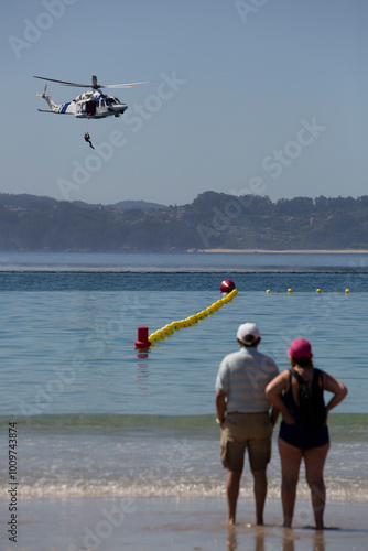 фотографія Maritime rescue helicopter rescues a bather on Silgar beach, Sanxenxo