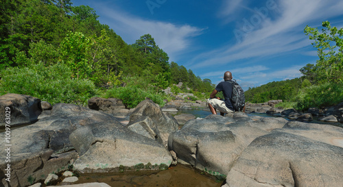 Foto Black man enjoying the scenery at Silver Mines Recreation sitting on a rock by a