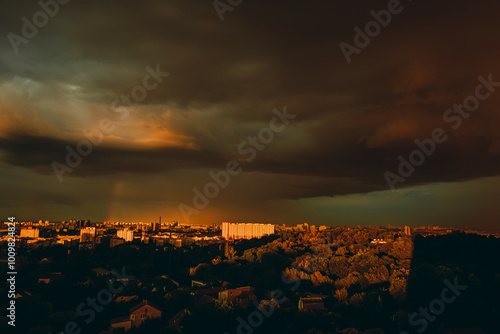 rainbow appeared against gray stormy sky over residential area of the city. photo