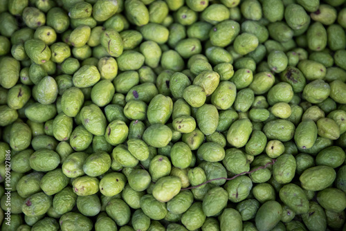 Green fresh olives on a stall for sale. Background.