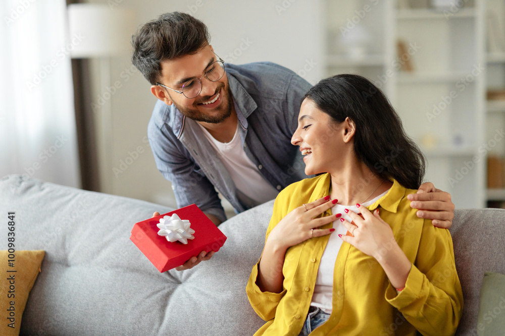 © Home-stock - Loving hindu husband giving present gift box to his beloved wife, celebrating birthday, having marriage anniversary celebration, copy space