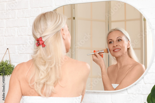 Mature woman doing makeup n...