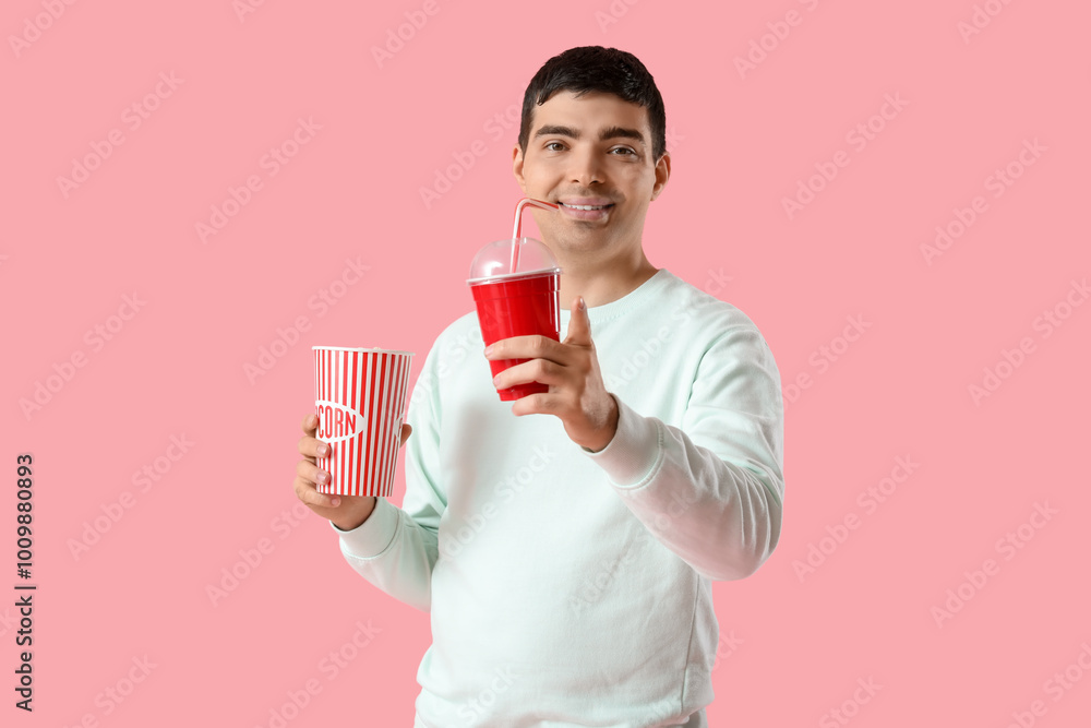 Happy young man with popcorn and soda on pink background Happy young man with popcorn and soda on pink background