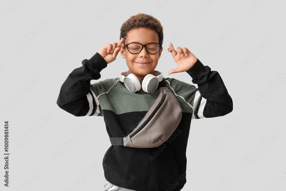 Little African-American boy with headphones making wish on white background Little African-American boy with headphones making wish on white background