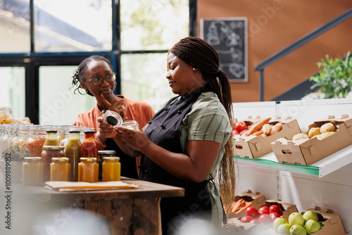 Billede på lærred African american female vendor giving a complimentary treat to loyal customer at environmentally friendly market