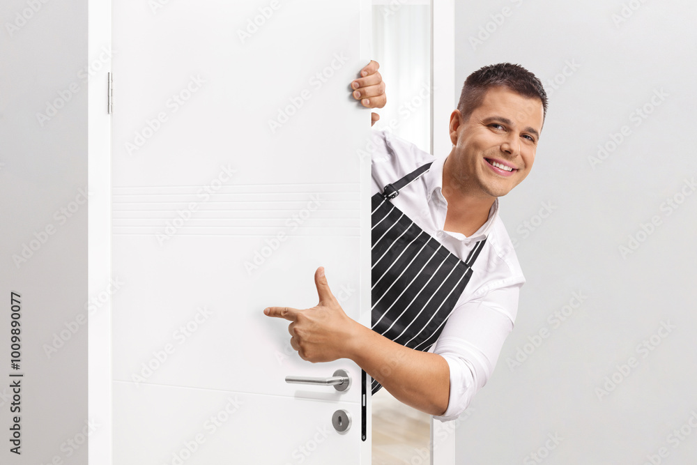 Man wearing an apron behind a door Man wearing an apron behind a door