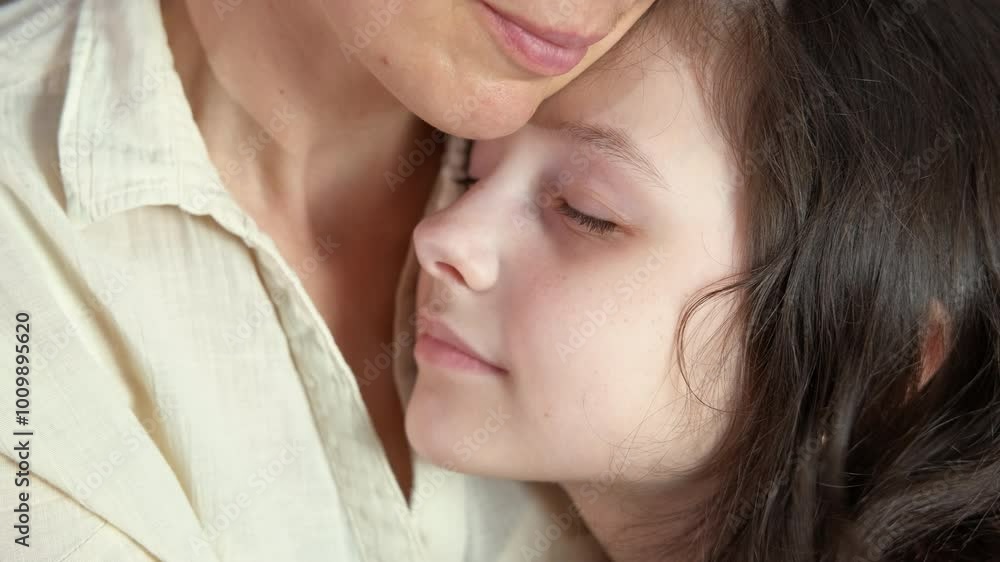Resting kid together with mum inside. A happy child resting by her mother and hugs her on the sofa. Resting kid together with mum inside. A happy child resting by her mother and hugs her on the sofa.