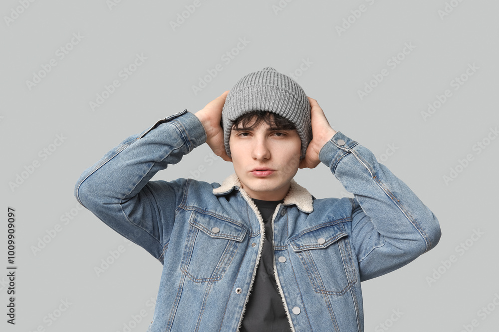 Handsome young man in stylish denim jacket on grey background Handsome young man in stylish denim jacket on grey background