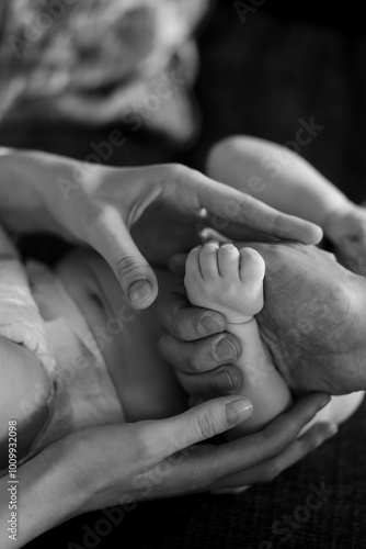 BW picture of baby's and parents hands close up 