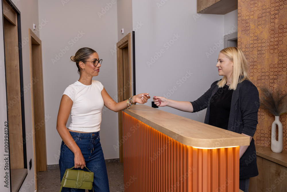 Obraz premium Young woman taking a key at the reception
