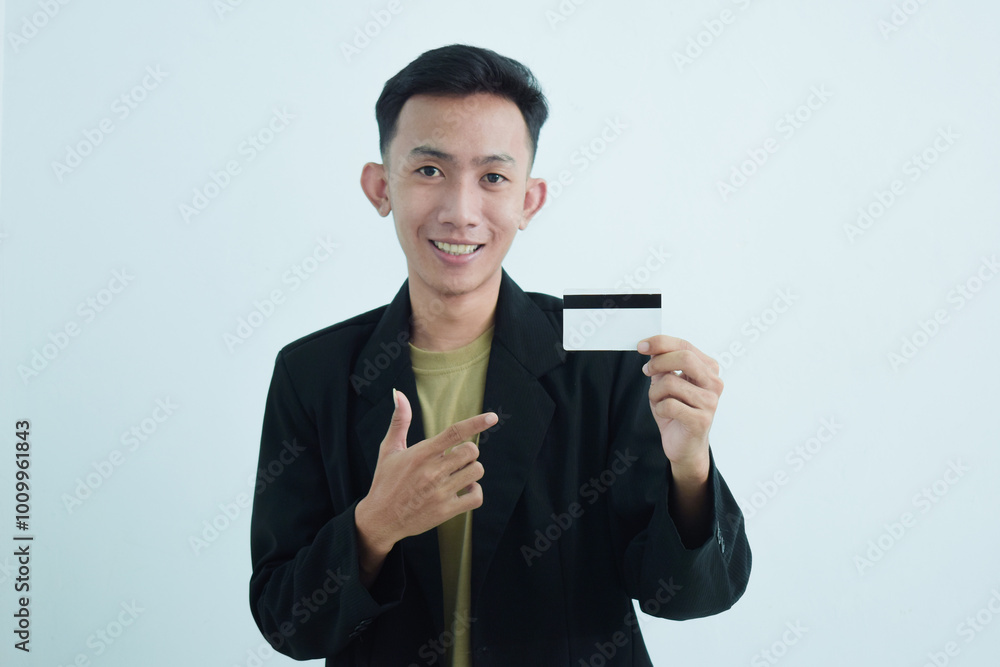 Joyful asian young businessman wear suit with tshirt and holding blank white credit card over white background Joyful asian young businessman wear suit with tshirt and holding blank white credit card over white background
