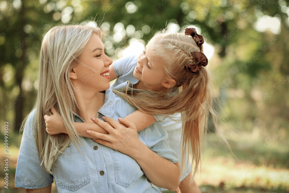 Fototapeta premium Happy mother with her little daughter hugging in park