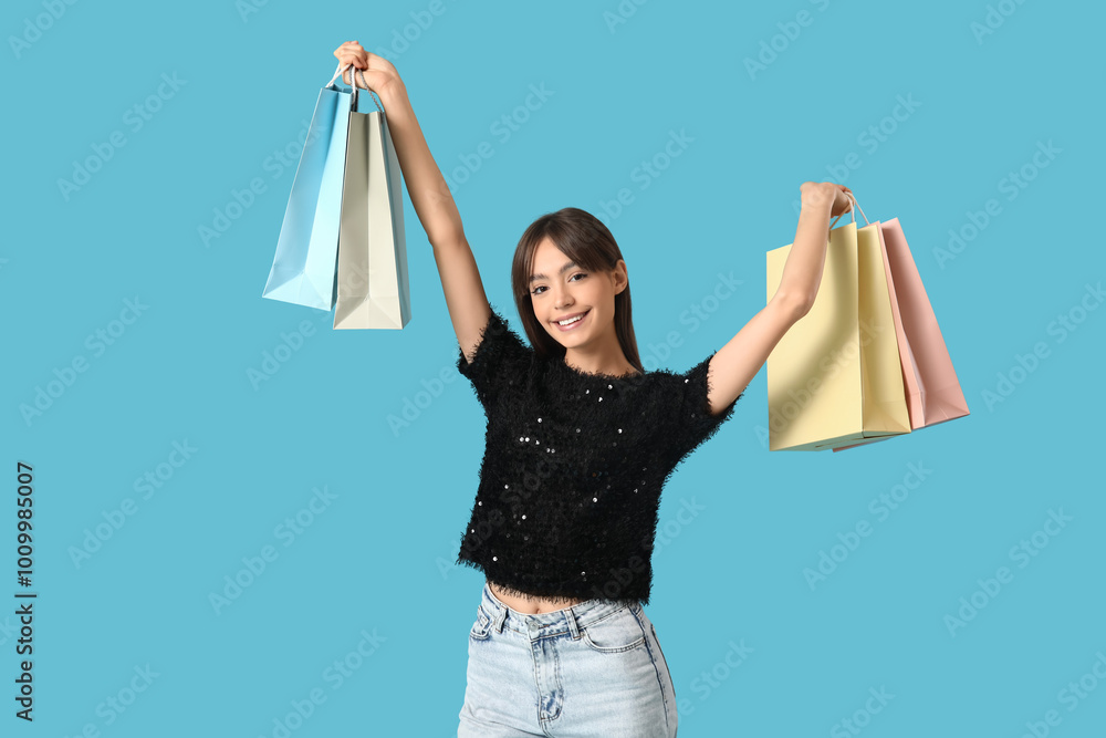 Young woman with shopping bags on blue background. Black Friday Sale Young woman with shopping bags on blue background. Black Friday Sale