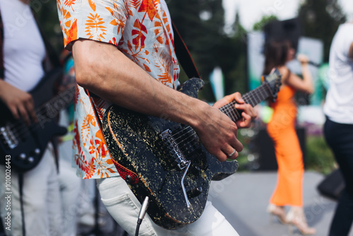 Canvas Print Concert view of electric guitar player with vocalist and rock band performing on