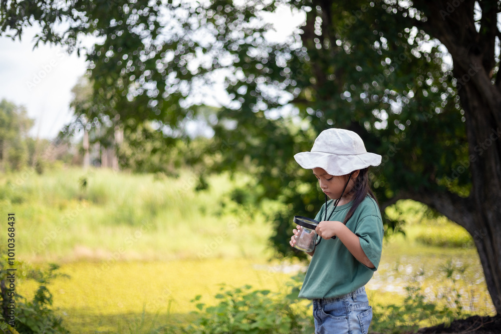 A young girl is looking through a magnifying glass at a plant A young girl is looking through a magnifying glass at a plant