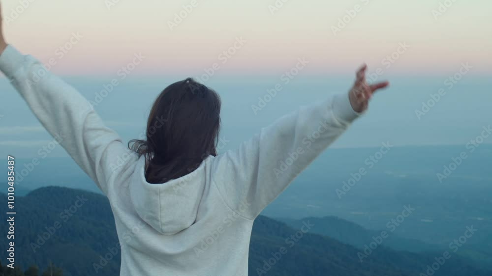 Woman raises hands up standing back on mountain top morning sun shine slow motion. Female silhouette figure in sportswear enjoy life wanderlust world. Person stretching after waking up Woman raises hands up standing back on mountain top morning sun shine slow motion. Female silhouette figure in sportswear enjoy life wanderlust world. Person stretching after waking up