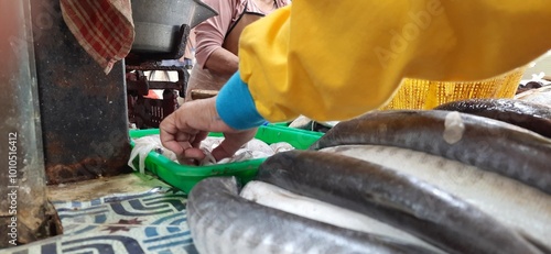 The atmosphere at the traditional market in Indonesia. Seller and buyer transaction. Various vegetables and basic daily necessities photo