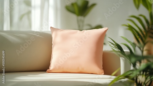 Soft peach cushion on a cozy couch with green plants in a bright  airy room.