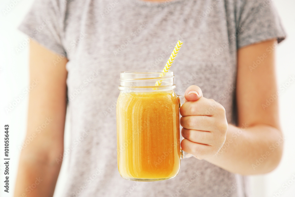 Fotomural Woman holding in hands glass jar with orange smoothie
