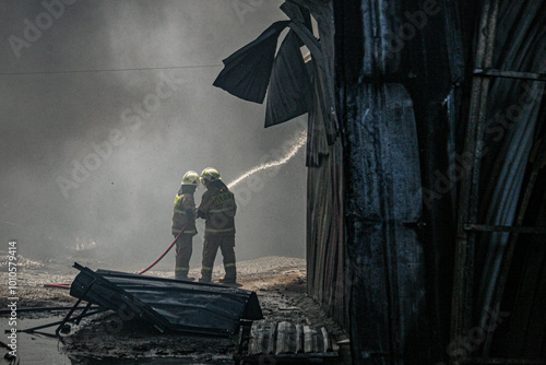 Firefighters extinguish a fire at a warehouse. photo