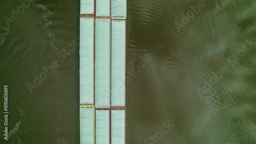 Top down aerial of tugboat pushing barge, scow, floating platform on missisipi river in Wisconsin, America. photo