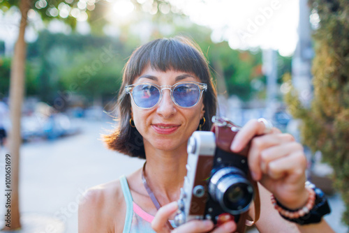 girl walks around the city and takes pictures with a camera. Close-up of a film camera.