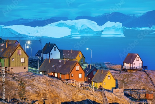 Baffin Bay, colorful typical houses in small village Uummannaq, Greenland Icefjord in Greenland and the silhouetted hight mountain ridge in the background under a blue
Melting icebergs by the coast of photo