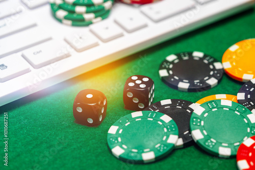 Chips and playing cards on a green felt surface near a computer keyboard during an online gaming session at home