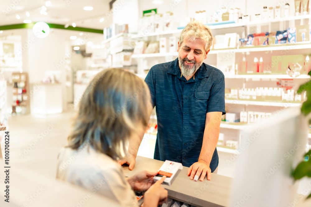 Pharmacist attending and talking to a customer in the counter Pharmacist attending and talking to a customer in the counter