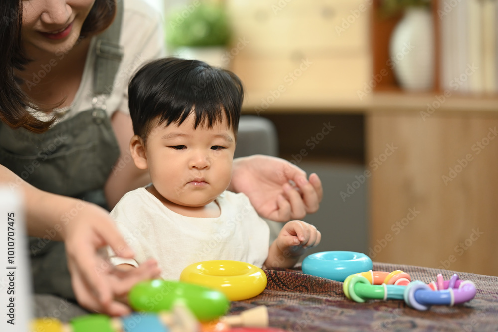 An adorable little boy and mother playing with colorful toys in a cozy living room An adorable little boy and mother playing with colorful toys in a cozy living room