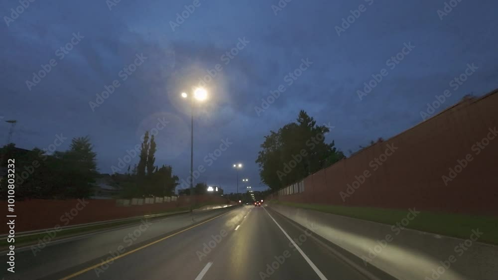 A road at night. The road is empty and the only light is coming from the street lights A road at night. The road is empty and the only light is coming from the street lights