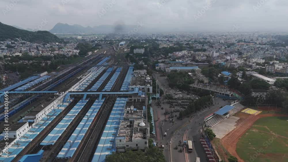 Aerial capture of Vijayawada’s dynamic urban environment with the peaceful natural hill adding scenic charm near railway station and ground Aerial capture of Vijayawada’s dynamic urban environment with the peaceful natural hill adding scenic charm near railway station and ground