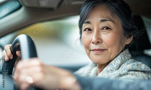 A middle aged japanese woman driving her car with hands on steering wheel