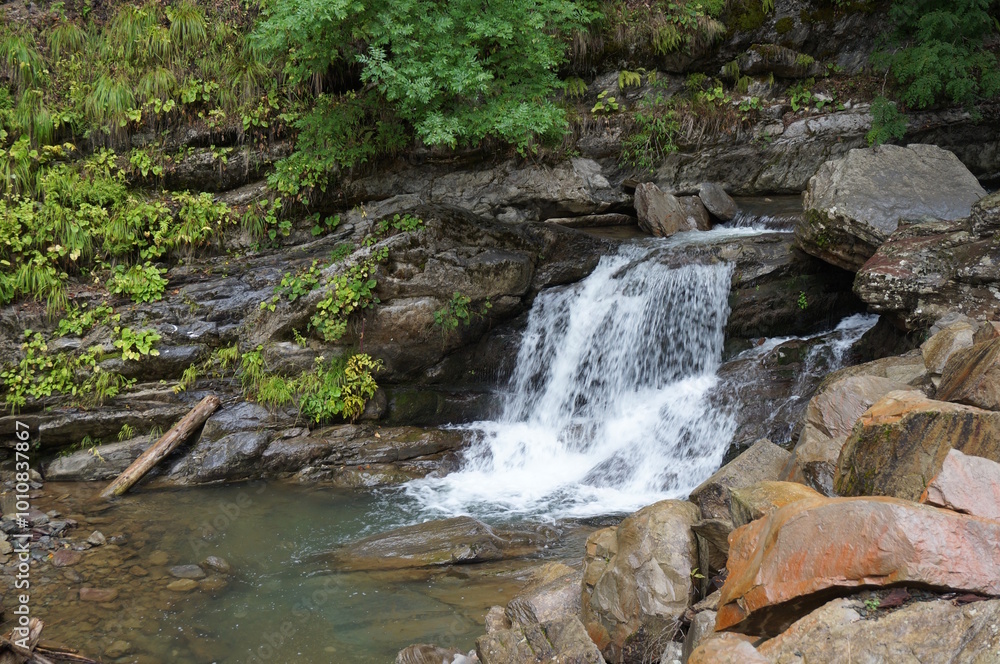 Fototapeta premium A beautiful waterfall in a mountainous and wooded area. Mendelikha Park.