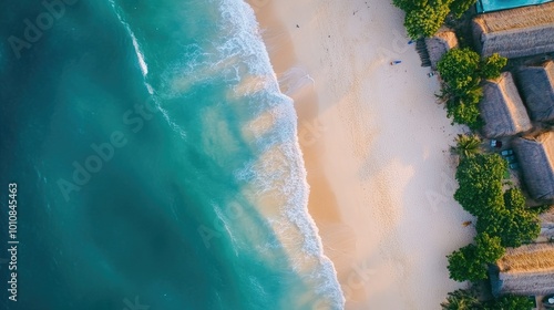 Aerial top-down shot of the Vietnam coast, with ocean waves gently crashing onto the sandy beach, creating a calm and serene vacation backdrop.