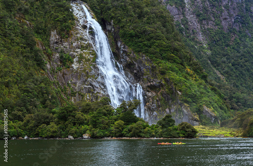 Fiordland National Park, Milford Sound, South Island, New Zealand - February 25, 2020: People enjoying kayaking under the Bowen Falls  photo