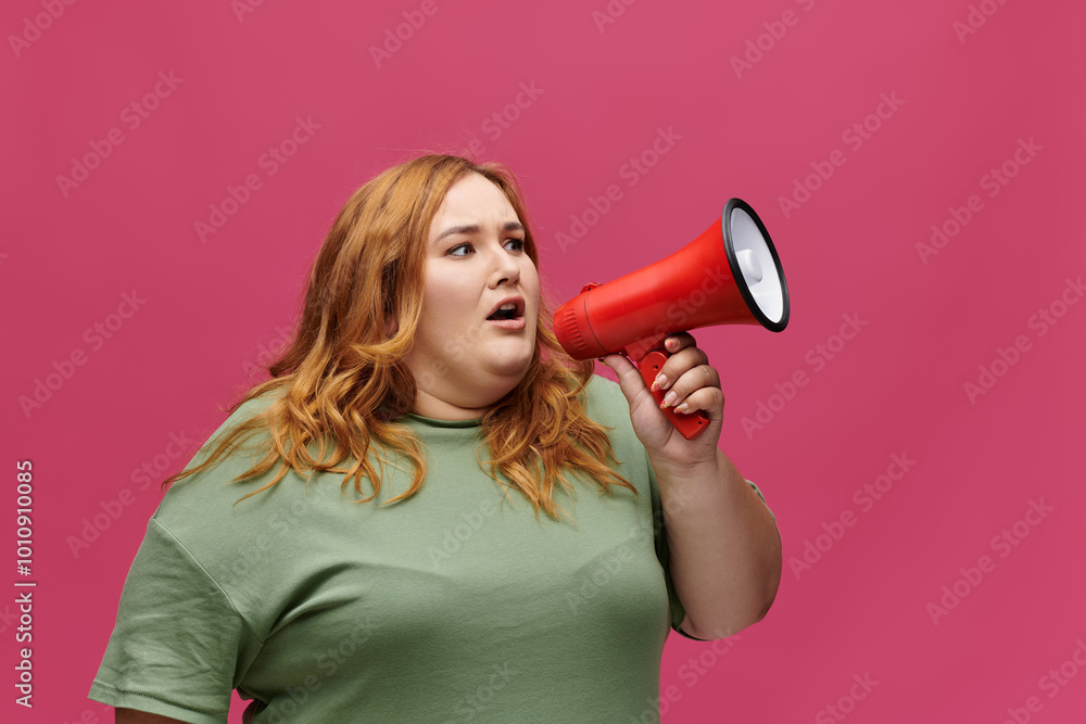 A woman with red hair yells into a megaphone. A woman with red hair yells into a megaphone.