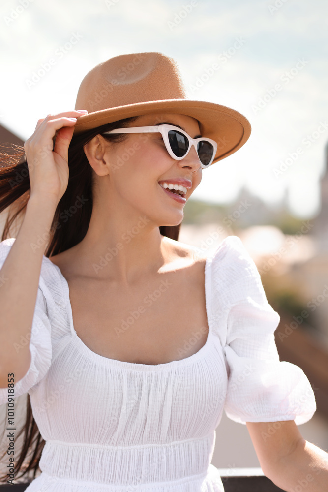 Smiling woman in stylish hat and sunglasses outdoors Smiling woman in stylish hat and sunglasses outdoors