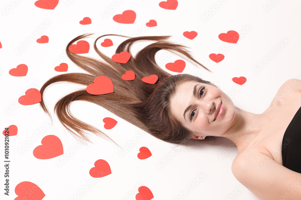 Φωτογραφία Beautiful young woman with long hair and red paper hearts on white background