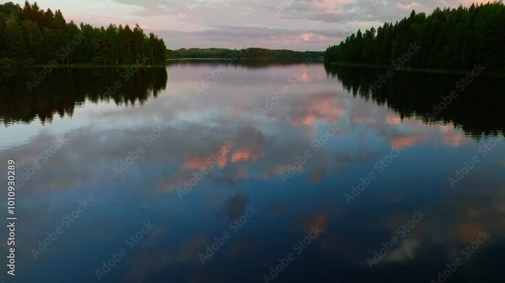 Quickly flying over vibrant sunset reflected in a forest lake close to the water Quickly flying over vibrant sunset reflected in a forest lake close to the water
