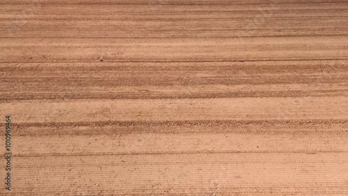 Bird’s-Eye View of Dry Cultivated Land with Geometric Patterns and Earthy Tones, for Wallpaper or Copy Space . Horizontal lines.