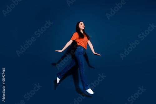 Wallpaper Mural Photo of gorgeous cheerful woman wear orange stylish clothes walk empty space isolated on dark blue color background Torontodigital.ca