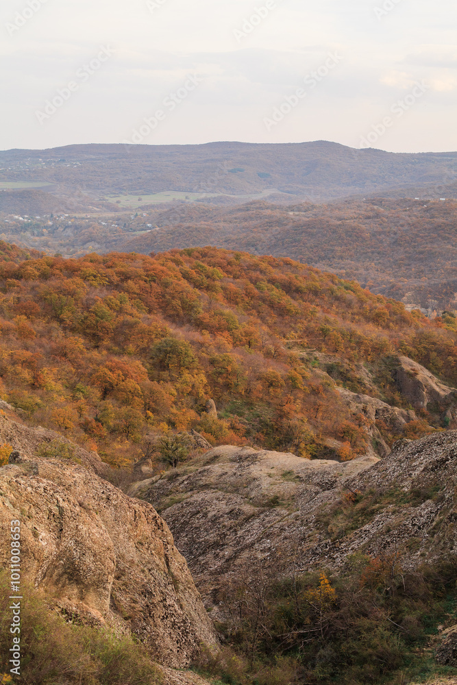 a panoramic view of autumn landscape with mountain hills surrounded by trees with yellow and red foliage at birtvisi canyon in georgia at a sunset light a panoramic view of autumn landscape with mountain hills surrounded by trees with yellow and red foliage at birtvisi canyon in georgia at a sunset light