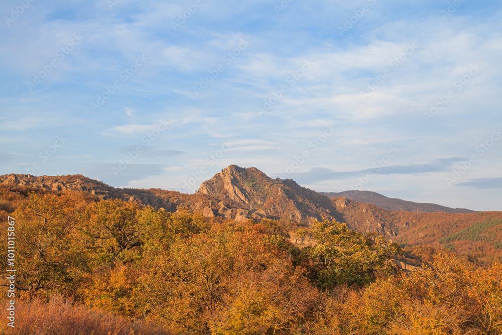 a panoramic view of autumn landscape with mountain hills surrounded by trees with yellow and red foliage at birtvisi canyon in georgia at a sunset light a panoramic view of autumn landscape with mountain hills surrounded by trees with yellow and red foliage at birtvisi canyon in georgia at a sunset light