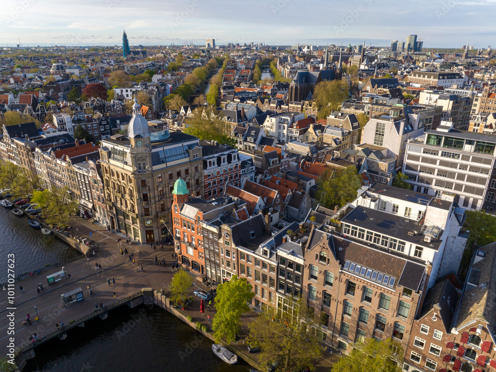 Historical Center of Amsterdam, Netherlands. Aerial Drone Shot of Traditional Dutch houses on narrow street and channel. Historical Center of Amsterdam, Netherlands. Aerial Drone Shot of Traditional Dutch houses on narrow street and channel.