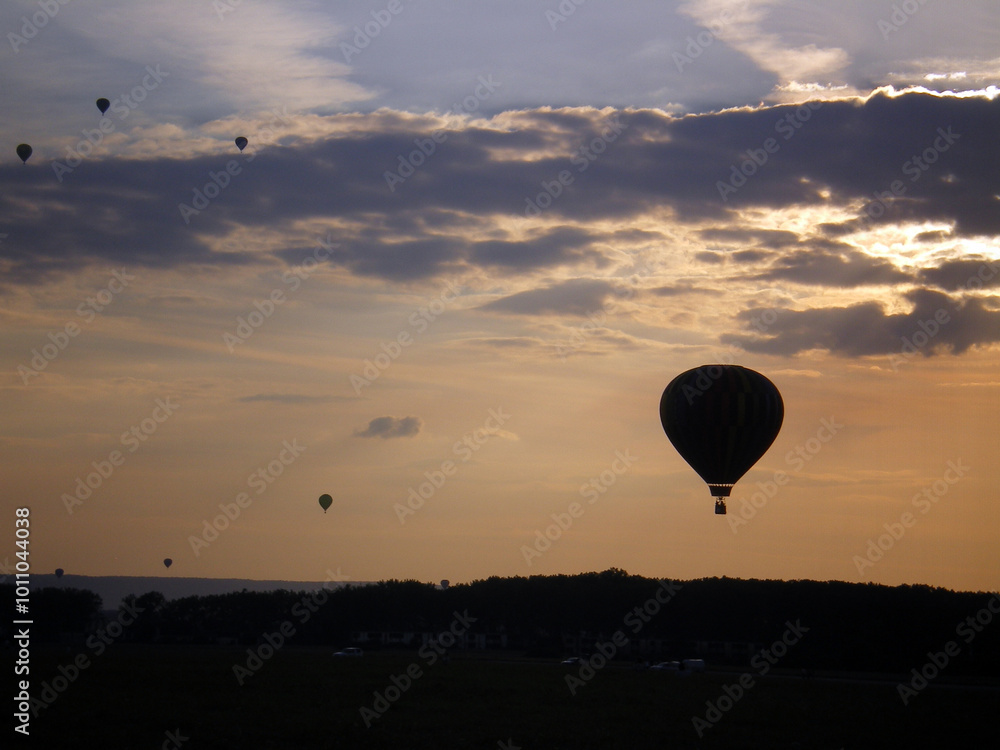 Chambley, France - July 28th 2007 : Lorraine mondial air ballons 2007. View of a group of balloons, with the sunset and some clouds. Chambley, France - July 28th 2007 : Lorraine mondial air ballons 2007. View of a group of balloons, with the sunset and some clouds.