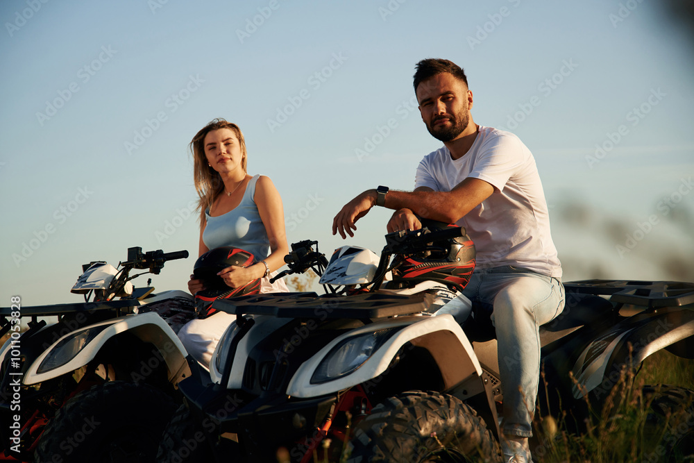 Naklejka premium Rest time, sitting and taking a break. Man and woman are on ATV outdoors