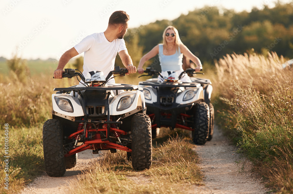 Fototapeta premium On the open rural road. Man and woman are on ATV outdoors