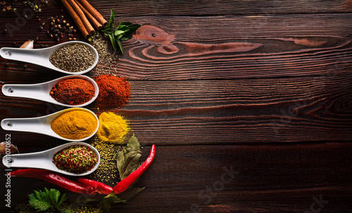 Colorful spices and legumes in wooden spoons on a wooden table. Healthy living and vegan diet.