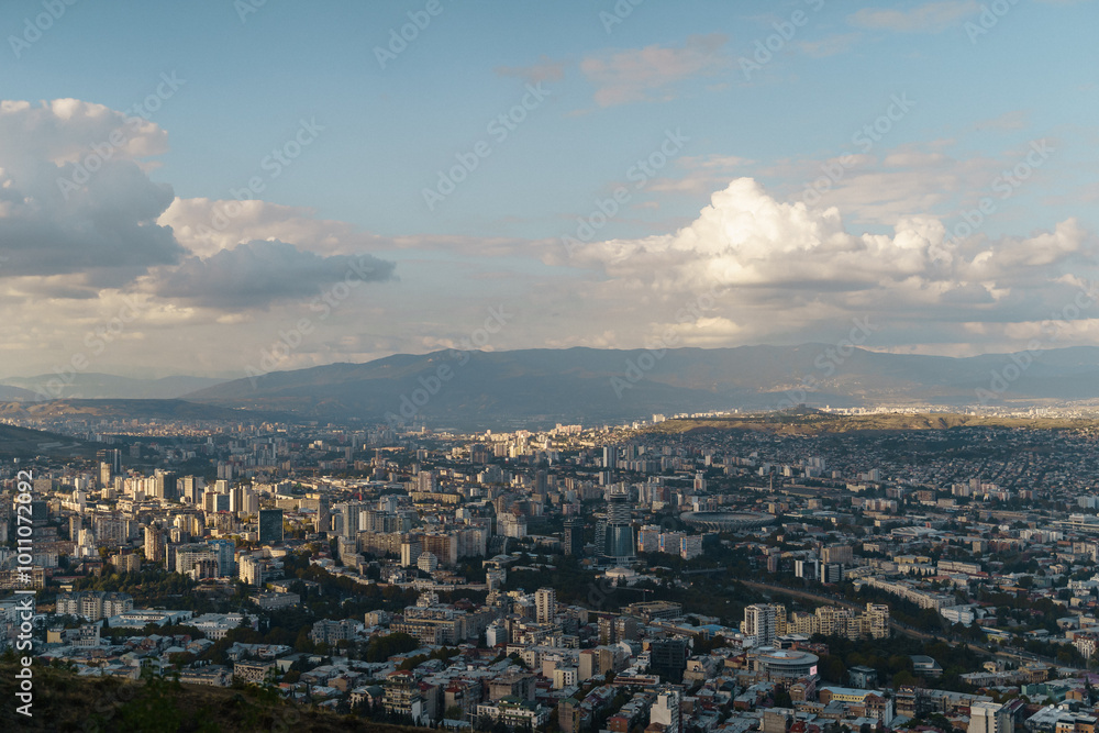 A breathtaking view of a sprawling city beneath a dramatic sky at sunset from a scenic vantage point A breathtaking view of a sprawling city beneath a dramatic sky at sunset from a scenic vantage point
